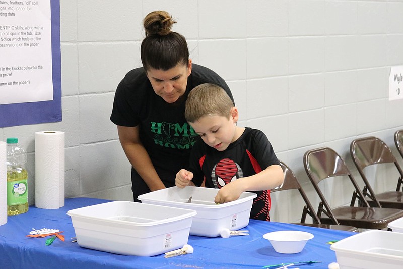 Anna Campbell/News Tribune
Heather and first grader Grady Hurst sort through a bucket "oil spill" at the science station Thursday at Blair Oaks Elementary's STEAM Night.