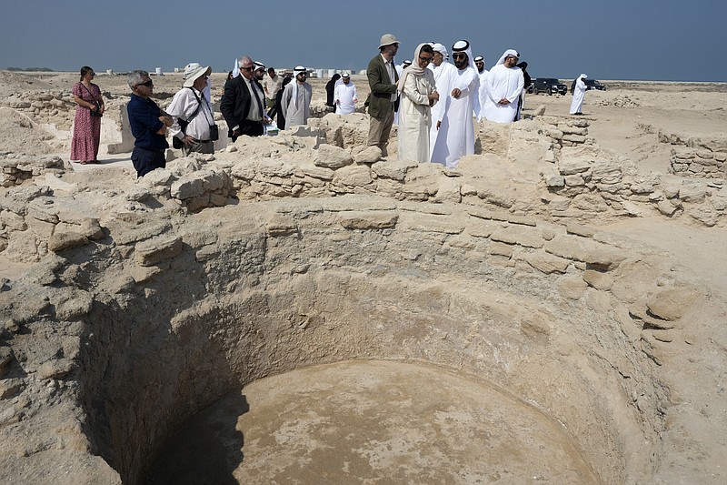Sheikh Majid bin Saud Al Mualla, chairman of the Umm Al Quwain Department of Tourism and Archaeology, front right, speaks to Noura Al Kaabi, UAE Minister of Culture and Youth, during a visit to the ancient Christian monastery on Siniyah Island on Thursday, Nov. 3, 2022, in Umm al-Quwain, United Arab Emirates. The monastery possibly dating as far back as the years before Islam rose across the Arabian Peninsula has been discovered on an island off the coast of the UAE, officials announced Thursday. (AP Photo/Kamran Jebreili)