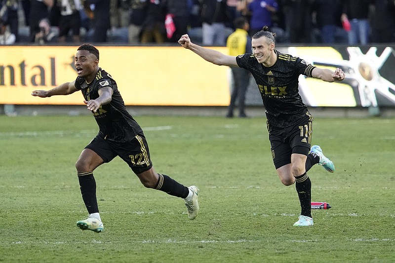 Los Angeles FC defender Diego Palacios (12) and forward Gareth Bale (11) celebrate after defeating the Philadelphia Union in a  penalty kick shootout to win the MLS Cup soccer match Saturday, Nov. 5, 2022, in Los Angeles. (AP Photo/Marcio Jose Sanchez)