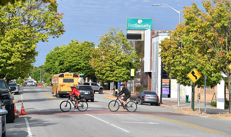 Cyclists ride Friday, Sept. 23, 2022, across Emma Avenue  near Shiloh Square in downtown Springdale. (NWA Democrat-Gazette/Andy Shupe)