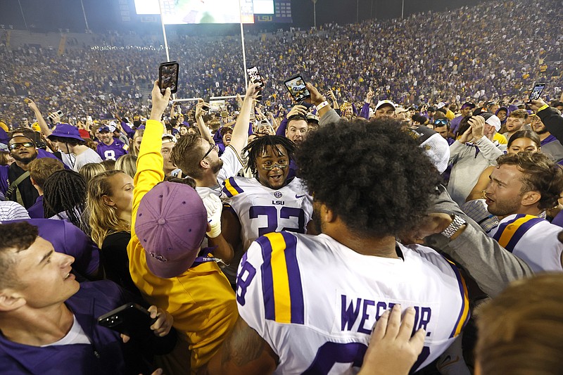 LSU offensive lineman Fitzgerald West Jr. (68) and linebacker DeMario Tolan (32) celebrate with fans who stormed the field after a game against Alabama Saturday in Baton Rouge, La. - Photo by Tyler Kaufman of The Associated Press