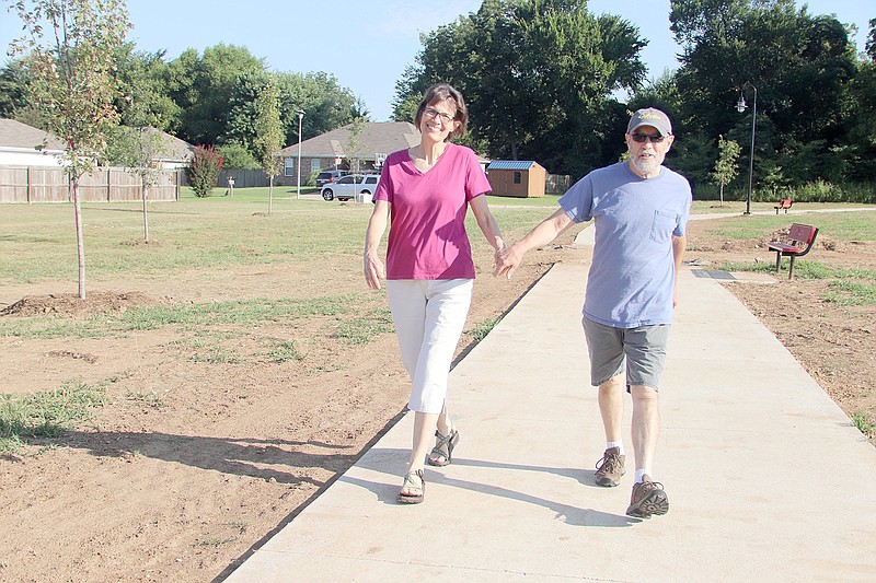 Jim and Lydia Hawkins, both of Fayetteville, walk on the trail at Creekside Park in Farmington in July 2019. Farmington was awarded $400,000 by the Arkansas Department of Transportation for work on the city's Creekside Park Trail.
(File Photo/NWA Democrat-Gazette)