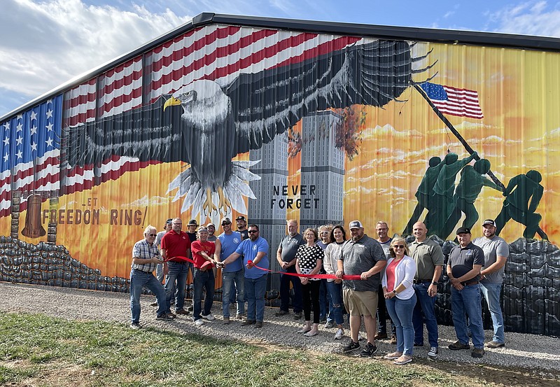 Democrat photo/Kaden Quinn 
The California Area Chamber Commerce stands with painter Dennis Holliday and Drinkard Construction, Get It, LLC owners Curt Drinkard and Josh Hoskins as they cut the ribbon to their company's new mural on Friday, Nov. 4.