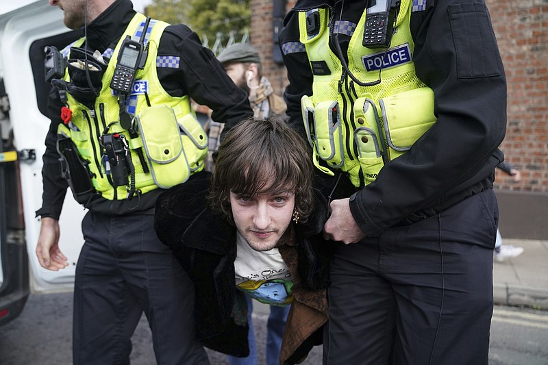 La policía detiene a un manifestante que pareció arrojar huecos al rey Carlos III y a la reina consorte cuando llegaron al Micklegate Bar, donde se recibe tradicionalmente al soberano en la ciudad de York, Inglaterra, el miércoles 9 de noviembre de 2022. (Jacob King/PA via AP)