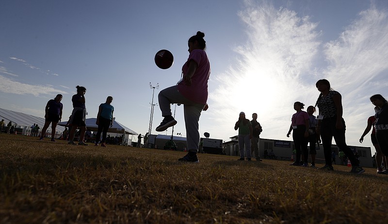 En esta imagen del 9 de julio de 2019 se ve a inmigrantes jugando al fútbol en el centro de retención para niños migrantes más nuevo del gobierno federal, en Carrizo Springs, Texas. (AP Foto/Eric Gay, Archivo)