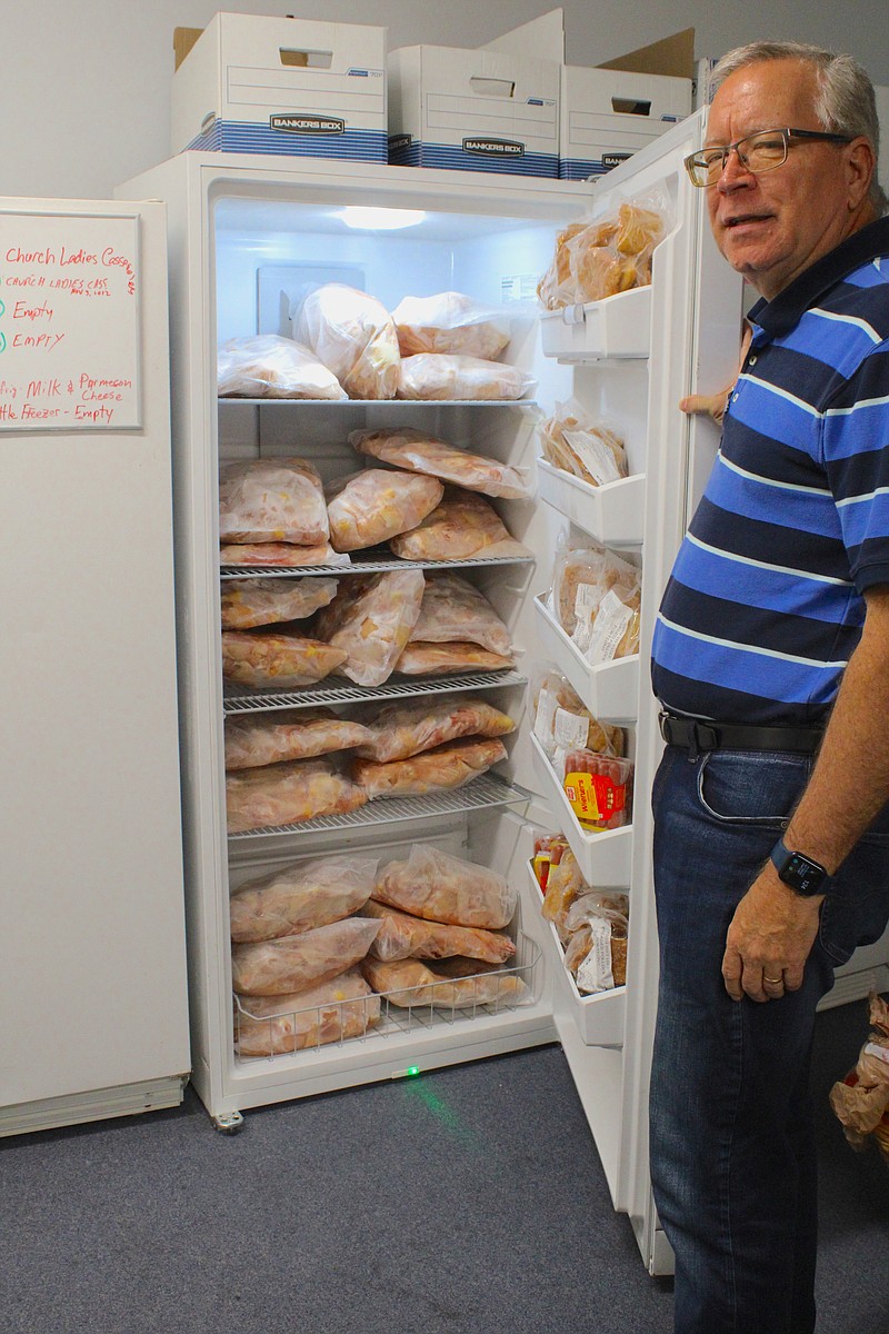 Joe Doyle shows a freezer full of chicken legs, part of the Interfaith Help Services food pantry, which was restocked on Thursday. IHS is asking the community for help to allow the nonprofit to continue to provide assistance to those in need. (Caitlan Butler/News-Times)