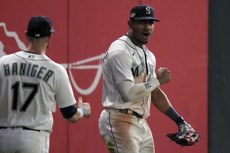 FILE - Seattle Mariners center fielder Julio Rodriguez, right, celebrates after making a catch for an out against the Houston Astros, during the 16 inning in Game 3 of an American League Division Series baseball game Saturday, Oct. 15, 2022, in Seattle. Rodríguez and Atlanta's Michael Harris II, a pair of 21-year-old center fielders, are baseball's Rookies of the Year. (AP Photo/Stephen Brashear, File)