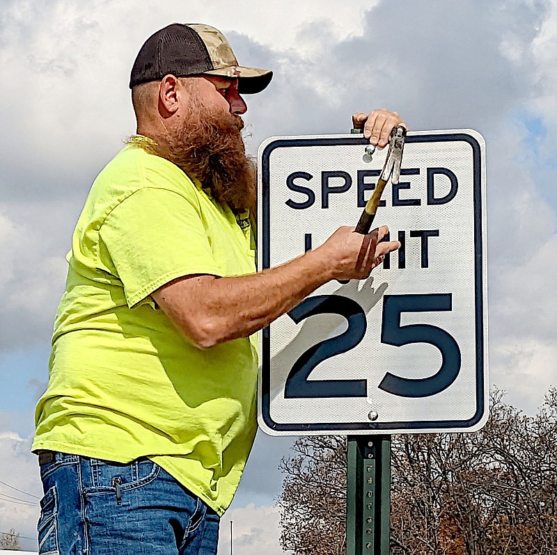 City of Gentry employee Wes Crawford changes a speed limit sign on Pioneer Lane from 30 mph to 25 mph on Nov. 9.

(NWA Democrat-Gazette/Randy Moll)