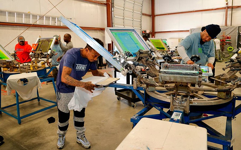 Tyrone Hollins, left, and Joseph Frasier work in the Turn 90 program screen printing shop. Turn 90 helps with the reentry process by helping formerly incarcerated men with life skills. (Tracy Glantz/The Island Packet/TNS)