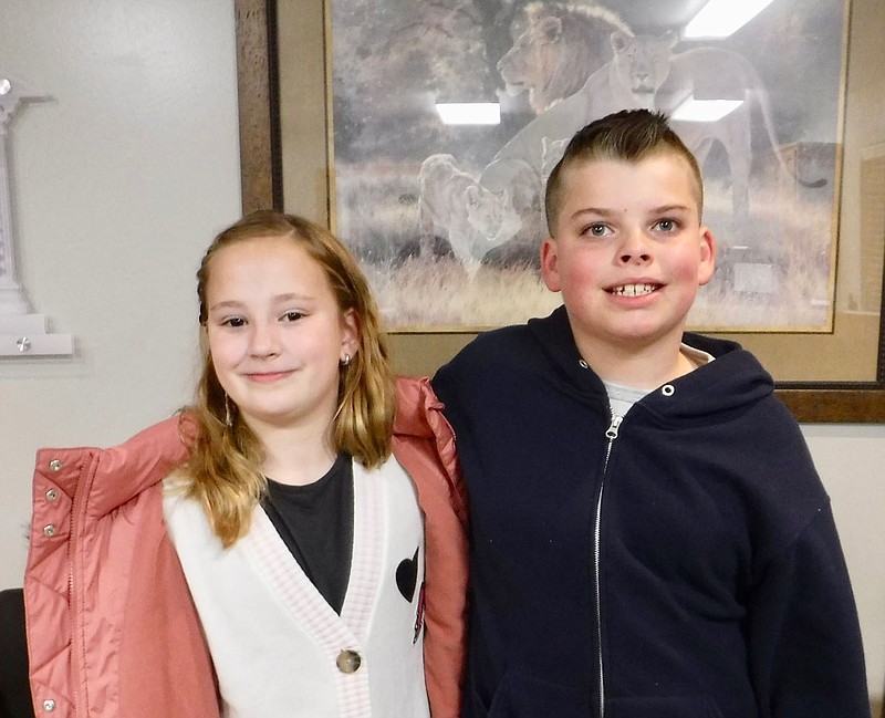 Westside Eagle Observer/SUSAN HOLLAND Vivian Whiteside, a third grader, and Jace Snyder, a fifth grader at Gravette Upper Elementary School, led the pledge of allegiance to the flag to open the November meeting of the Gravette School Board. These Odyssey of the Mind participants were welcomed and then introduced themselves and told what they liked best about Odyssey of the Mind.