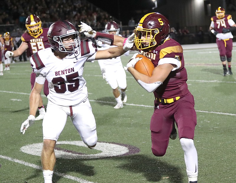 Lake Hamilton's Justin Crutchmer (5) runs for a gain as Benton's Christopher Barnard (35) defends on Oct. 29, 2021 at Wolf Stadium. Usually a conference matchup in previous seasons, Lake Hamilton meets Benton in the quarterfinals of the playoffs Friday night in an East versus West contest. - File Photo by The Sentinel-Record