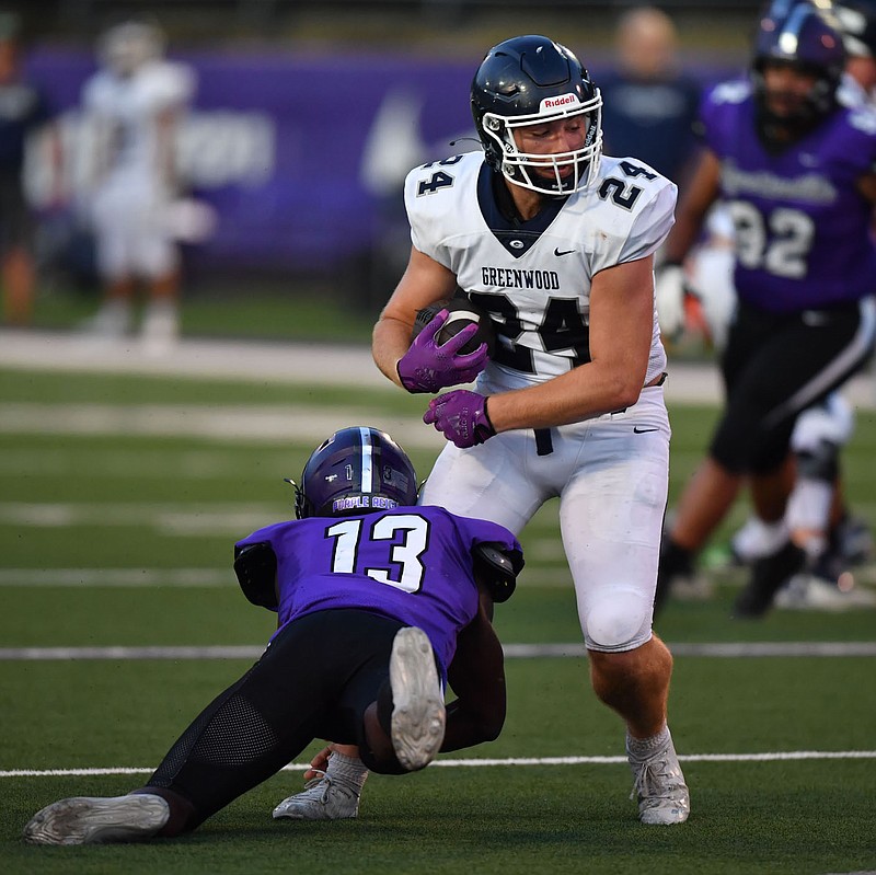 Greenwood receiver Aiden Kennon (24) carries the ball Tuesday, Aug. 16, 2022, as he is hit by Fayetteville defensive back Isaiah Taylor (13) during the first half at Harmon Stadium in Fayetteville. Greenwood will host Russellville tonight in a Class 6A state playoff game at Smith-Robinson Stadium.
(NWA Democrat-Gazette/Andy Shupe)