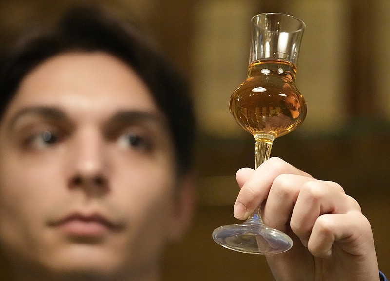 A bartender looks at a glass of plum brandy Nov. 11 in Belgrade, Serbia. (AP/Darko Vojinovic)