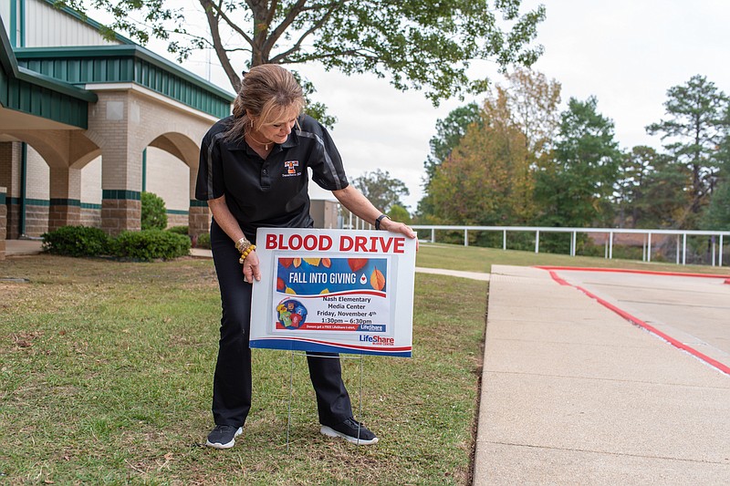 Sonya Freeze secures the blood drive yard sign Friday, Nov. 4, 2022, at Nash Elementary School in Nash, Texas, as parents, family and friends visit the campus to donate blood to LifeShare Blood Center. Starting Saturday, Nov. 19, the center is hosting 18 blood drives over five days throughout the area to meet increased demand during the holidays. (File photo)