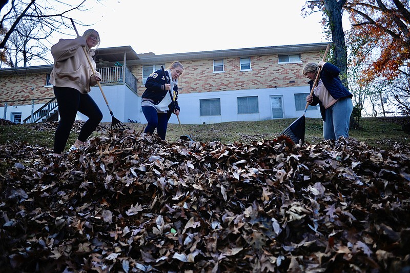 Joe Gamm/News Tribune
Madi Trachsel (from left) Landrey VanOverscheldt, both Helias High School students, and Mackenzie Davis from Blair Oaks High School rake leaves away from a veteran's home early Friday afternoon as part of Operation Leaf Relief.