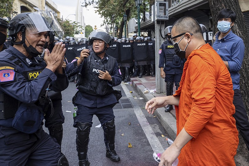 Police gesture in respect towards a monk as they block protesters trying to march to the Asia-Pacific Economic Cooperation APEC summit venue, Friday, Nov. 18, 2022, in Bangkok, Thailand. (AP Photo/Wason Wanichakorn)