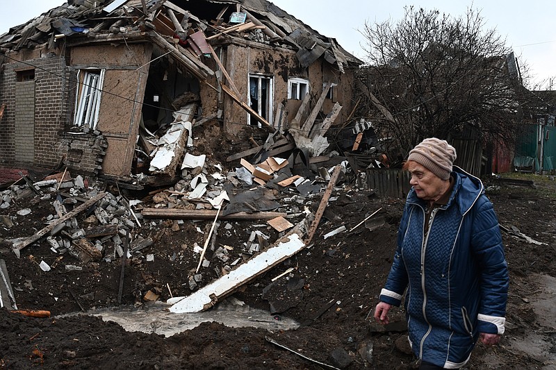 A woman walks past her house that was damaged in Russian shelling in Kramatorsk, Ukraine, Saturday, Nov. 19, 2022. (AP Photo/Andriy Andriyenko)