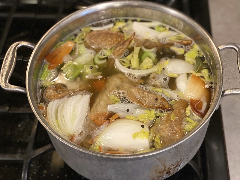 Vegetables and turkey parts cook on a stove to make turkey stock in New Milford, Conn. in November 2022. (Katie Workman via AP)