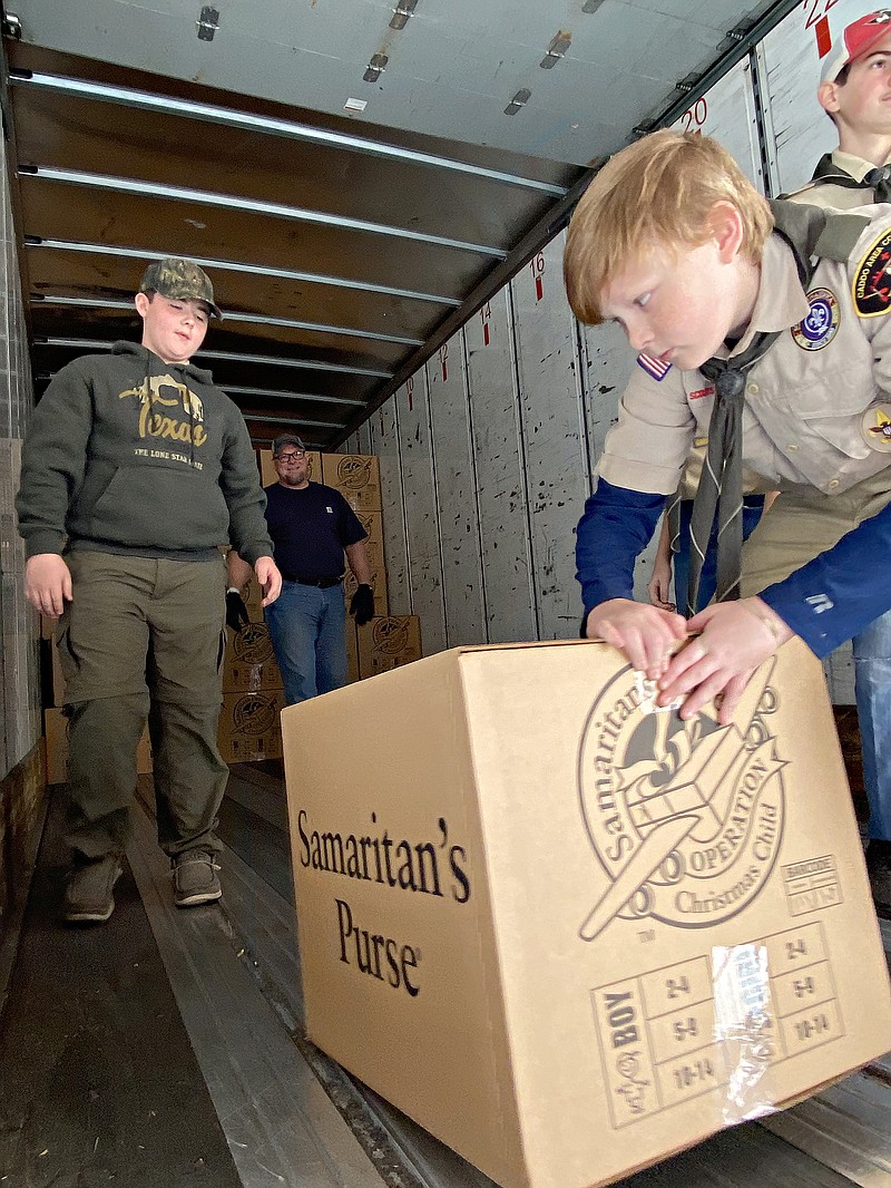Boy Scout Brendan Morton loads a crate filled with shoeboxes for Operation Christmas Child as fellow Scout Keigan Owens, left, prepares to move the box to the back of a semi-trailer Monday afternoon, Nov. 21, 2022, at Cross View Baptist Church in Texarkana, Texas. The Scouts are with Troop 30 in Redwater, Texas. In all, the Texarkana area collected 35,000 shoeboxes during National Collection Week. (Staff photo by Stevon Gamble)