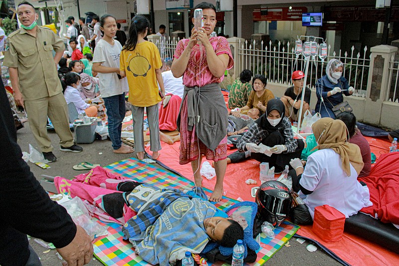 Earthquake survivors are treated outside of a hospital Monday, Nov. 21, 2022, in Cianjur, West Java, Indonesia. An earthquake shook Indonesia's main island of Java on Monday damaging dozens of buildings and sending residents into the capital's streets for safety. (AP Photo/Kholid)