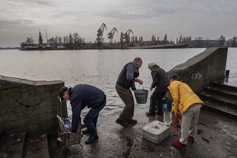 Residents of the recently liberated city of Kherson collect water from the Dnipro river bank, near the front line of the war, on Monday, Nov. 21, 2022, in southern Ukraine. (AP Photo/Bernat Armangue)