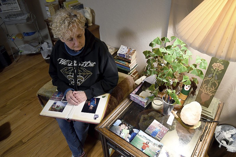 Sabrina Aston looks at childhood photos of her 28-year-old son, Daniel Aston, in her home in Colorado Springs, Colo., on Sunday, Nov. 20, 2022. Daniel Aston was one of five people killed when a gunman opened fire in a gay nightclub in Colorado Springs on Saturday night. (AP Photo/Thomas Peipert)