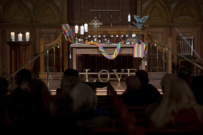 A pride flag wraps around the altar at First Congregational Church during a vigil for the victim's of Saturday's fatal shooting at Club Q on Monday, Nov. 21, 2022, in Colorado Springs, Colo. (AP Photo/ Parker Seibold)