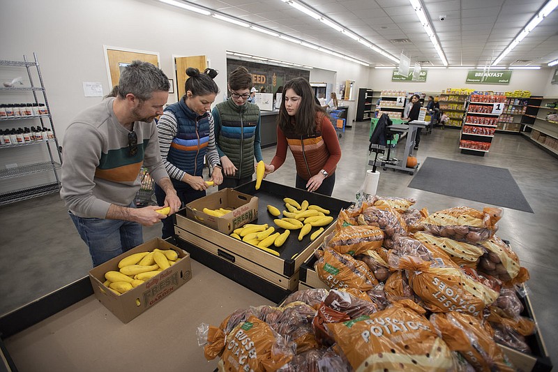 Volunteers Clay Adams (from left) of Bentonville, his wife Kate Adams and their children Fletcher Adams, 13, and Olivia Adams, 16, sort squash Wednesday at Feed Rogers, a food pantry operated by the Northwest Arkansas Food Bank. It’s set up like a grocery store, letting people choose items they need. Feed Rogers is located at 216 S. 13th St. Rogers. Visit nwaonline.com/221125Daily/ for today’s photo gallery.
(NWA Democrat-Gazette/J.T. Wampler)