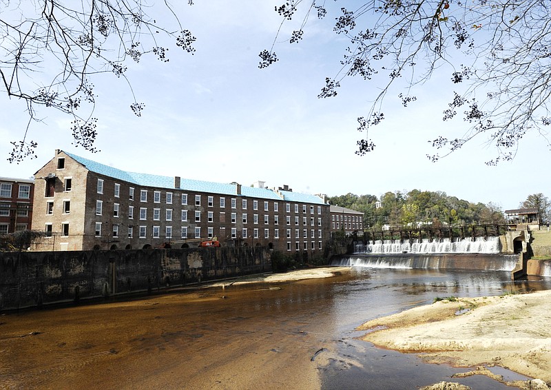 A once-abandoned cotton gin factory that is being renovated into apartments stands beside Autauga Creek in Prattville, Ala., on Thursday, Nov. 10, 2022. The factory's history is tied up in slavery, and the project demonstrates the difficulty of telling complicated U.S. history. (AP Photo/Jay Reeves)
