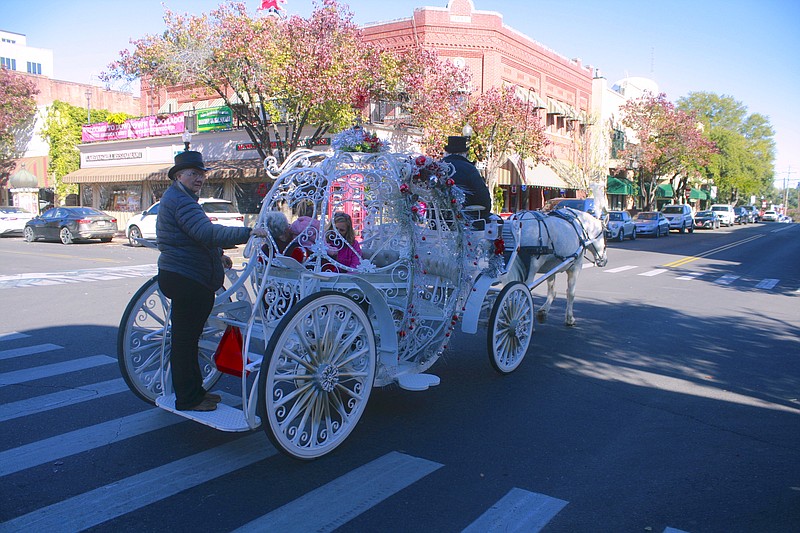 Shoppers take a horse and carriage ride in downtown El Dorado on Saturday, Nov. 19, during the Downtown Open House. Tonight, local residents are invited back downtown to begin their holiday shopping as retailers on the square offer Black Friday deals. (Matt Hutcheson/News-Times)