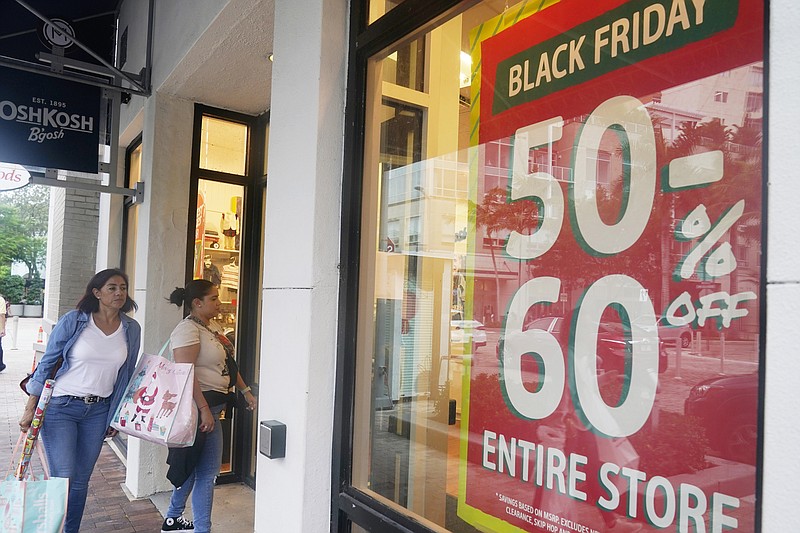 Shoppers looking for bargains enter an OshKosh children clothing store, Monday, Nov. 21, 2022, in Miami, Fla. Bargain hunting is back with full force heading into the holidays. But inflation is limiting how much of a deal consumers will be getting. (AP Photo/Marta Lavandier)