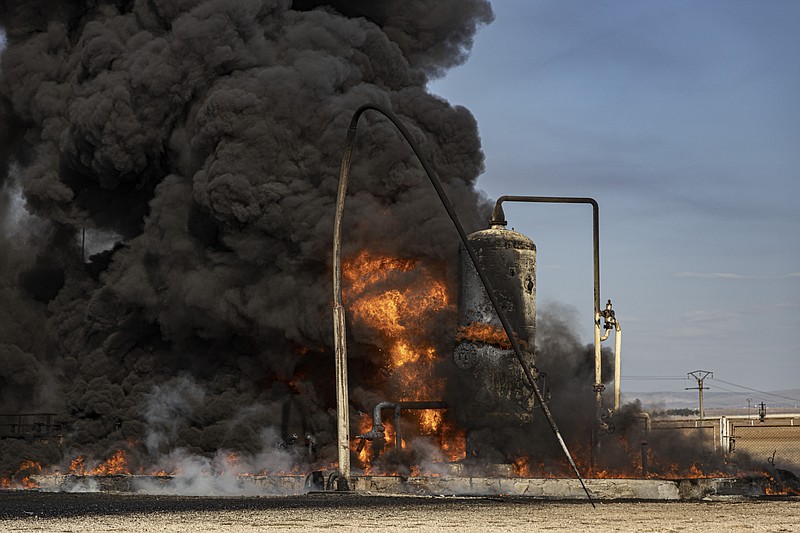 A smoke rises from an oil depot struck by Turkish air force  near the town of Qamishli, Syria, Wednesday, Nov. 23, 2022. Turkey's president says he will carry out a land invasion into Kurdish areas of northern Syria. Recep Tayyip Erdogan's statement in Ankara Wednesday came after Turkey carried out a barrage of airstrikes on suspected Kurdish militants in northern Syria and Iraq in recent days. (AP Photo/Baderkhan Ahmad)