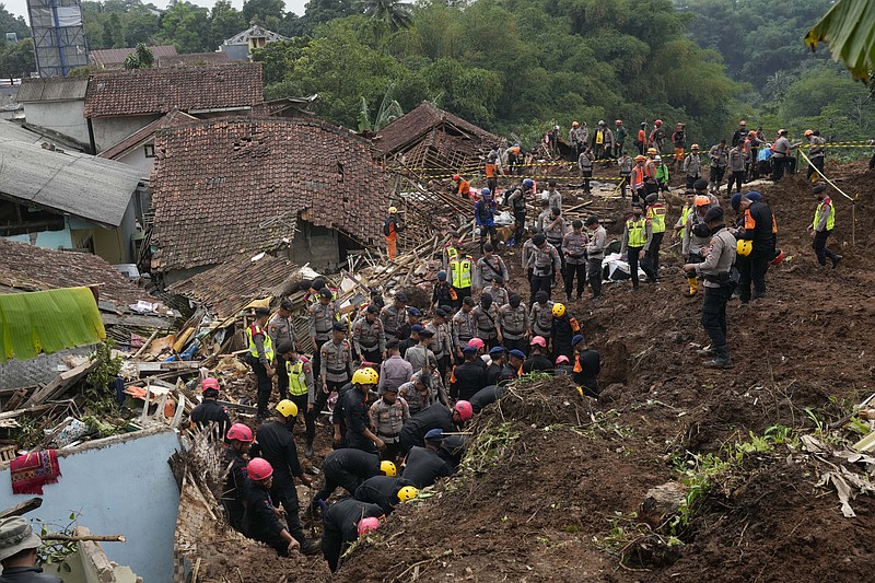 Rescuers search for victims in a village hit by an earthquake-triggered landslide in Cianjur, West Java, Indonesia, Thursday, Nov. 24, 2022. On the fourth day of an increasingly urgent search, Indonesian rescuers narrowed their work Thursday to the landslide where dozens are believed trapped after an earthquake that killed hundreds of people, many of them children. (AP Photo/Tatan Syuflana)