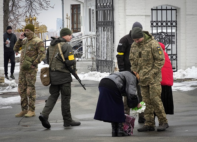 Ukraine's secret service examine belonging of a parishioner at the entrance to the Pechersk Lavra monastic complex in Kyiv, Ukraine, Tuesday, Nov. 22, 2022. Ukraine's counter-intelligence service, police officers and the country's National Guard searched one of the most famous Orthodox Christian sites in the capital, Kyiv, after a priest spoke favorably about Russia &#x2013; Ukraine's invader &#x2013; during a service. (AP Photo/Efrem Lukatsky)