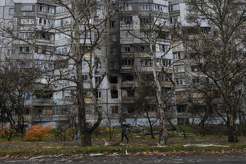 A woman walks past a recently damaged building due to a Russian strike in Kherson, southern Ukraine, Friday, Nov. 25, 2022. A barrage of missiles struck the recently liberated city of Kherson for the second day Friday in a marked escalation of attacks since Russia withdrew from the city two weeks ago following an eight-month occupation. (AP Photo/Bernat Armangue)