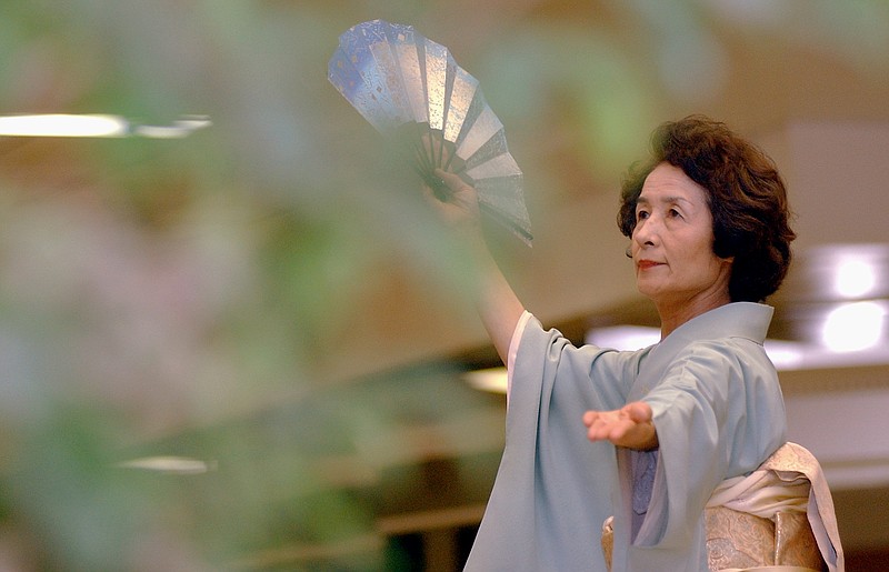 Sachiko Murakawa of Hanamaki, Japan, demonstrates takasagoya, a traditional celebration dance for weddings, at the former Hot Springs Mall in October 2004. It was one of many events that highlighted the Hanamaki delegation's visit to Hot Springs. - File photo by The Sentinel-Record