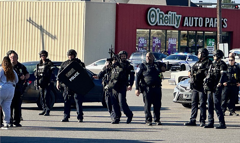 Hot Springs police SWAT team officers stand guard to keep spectators back in the parking lot at 1300 Albert Pike Road shortly after an allegedly armed suspect was arrested following a one-hour standoff Monday morning. - Photo by Mark Gregory of The Sentinel-Record
