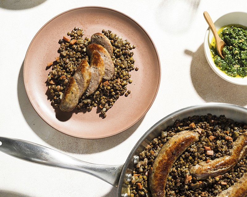 This image released by Milk Street shows a recipe for Braised Sausages with Lentils. (Milk Street via AP)