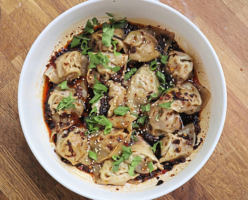 Bathed in fiery sauce enlivened with garlic and Sichuan peppercorn, these pork-stuffed wontons are a spicy bowl of perfection. (Gretchen McKay/Pittsburgh Post-Gazette/TNS)