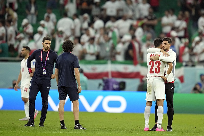 Iran's Ramin Rezaeian (23) is consoled after losing 1-0 to the United States in a World Cup group B soccer match between Iran and the United States at the Al Thumama Stadium in Doha, Qatar, Tuesday, Nov. 29, 2022. (AP Photo/Ashley Landis)
