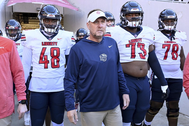 Liberty head coach Hugh Freeze, center, gets ready to take the field with his team to play Arkansas Nov. 5 in Fayetteville. - Photo by Michael Woods of The Associated Press