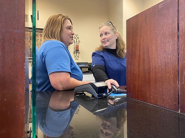 Heather Engledowl, an administrative assistant, left, and Lori Osborn, a licensed practical nurse, work at the front desk of the newly opened Family Medical Group of Texarkana on Thursday, Dec. 1, 2022, at 4105 N. Kings Highway in Texarkana, Texas. This is now FMG's third location in Texarkana, at the building formerly known as the Knighton Center. FMG offers primary care services, as well as occupational health, preventative care and transitional care. (Staff photo by Andrew Bell)