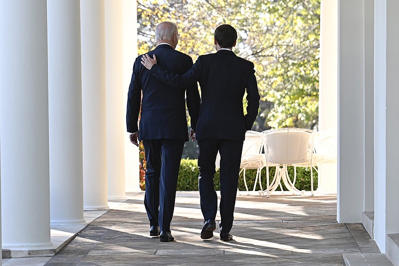 President Joe Biden and French President Emmanuel Macron walk along the Colonnade of the White House in Washington, Thursday, Dec. 1, 2022. (Jim Watson/Pool Photo via AP)