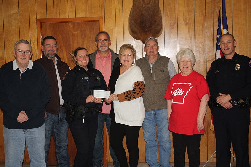 Texarkana Arkansas Police Department representatives accept at $2,000 donation Thursday, Dec. 1, 2022, from the Elks Lodge for Shop with a Cop. Pictured are, from left, Bob Fontham, TAPD officers Andy Anthony and Kristen Beach, Rick Schanfish, Debbi Smith, Herman Smith, Betty Templeton and Cpl. Kelly Pilgreen. Shop with a Cop provides holiday gifts for children. (Staff photo by Mallory Wyatt)