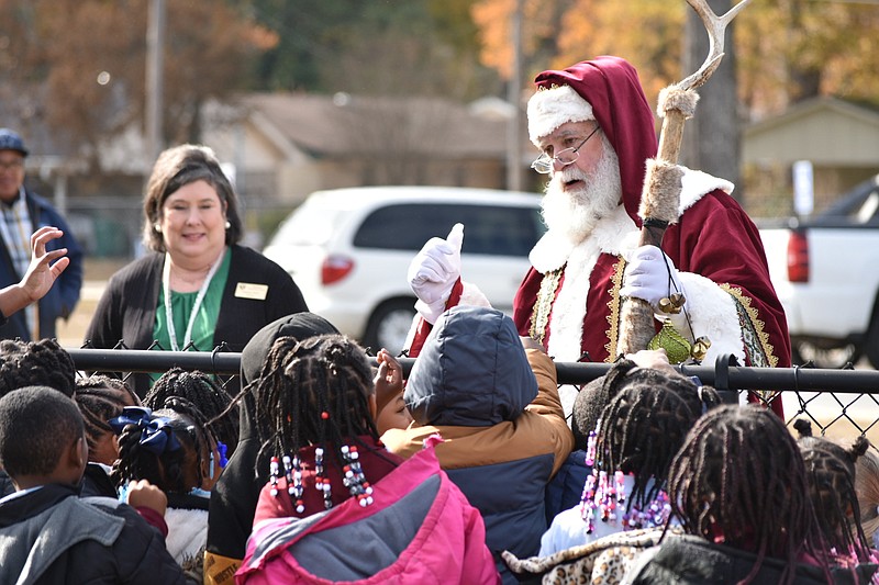 Santa Claus talks to children at Edgewood Elementary School in the Watson Chapel School District on Thursday afternoon as Principal Annette Neely, left, looks on. Edgewood was one of five elementary campuses in Pine Bluff and White Hall that Santa visited. For more on Santa's flight, see inside for a mini-gallery. (Pine Bluff Commercial/I.C. Murrell)