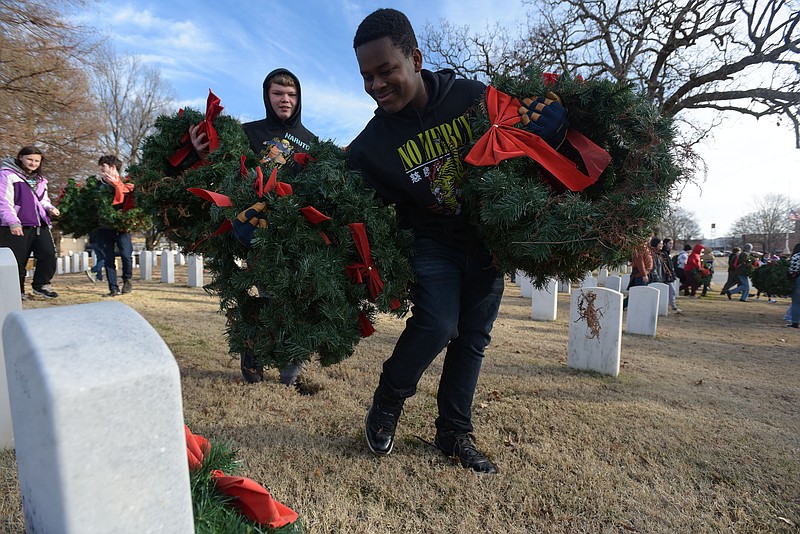 Mista Perry (right) and Alan Domer, freshmen ROTC cadets from Fort Smith Southside, gather wreaths on Jan. 5 at the Fort Smith National Cemetery. 
(File Photo/NWA Democrat-Gazette/Hank Layton)