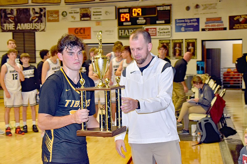MARK HUMPHREY ENTERPRISE-LEADER/Prairie Grove junior Austin Henry accepts the second place trophy after Marshall beat Prairie Grove, 52-32, in Saturday’s championship game of the Duel in the Dome boys basketball tournament hosted by West Fork. Henry scored six points on a pair of 3-point shots to start the tournament with a 43-37 win over Cedarville on Monday, Nov. 28, 2022.