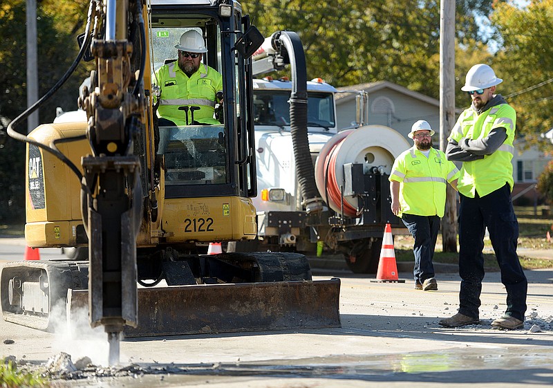 Scott Ballard (left) of the Fort Smith Utility Department operates a drill on Nov. 15, 2021, as fellow workers Jesse Hendricks (center) and Zach Chambers look on near the corner of Phoenix Avenue and South 24th Street in Fort Smith to begin the process of creating a new manhole for the sewer line. 
(File Photo/River Valley Democrat-Gazette/Hank Layton)