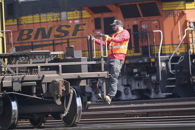 A worker rides a rail car at a BNSF rail crossing in Saginaw, Texas, Wednesday, Sept. 14, 2022. Most railroad workers weren't surprised that Congress intervened this week to block a railroad strike, but they were disappointed because they say the deals lawmakers imposed didn't do enough to address their quality of life concerns about demanding schedules and the lack of paid sick time.  (AP Photo/LM Otero, File)
