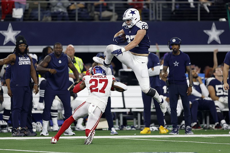 Jake Ferguson (87) of the Dallas Cowboys jumps over Jason Pinnock (27) of the New York Giants during the second half at AT&amp;T Stadium on November 24, 2022, in Arlington, Texas. (Wesley Hitt/Getty Images/TNS)